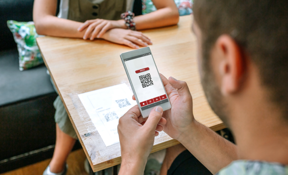Man scanning QR code menu in a restaurant