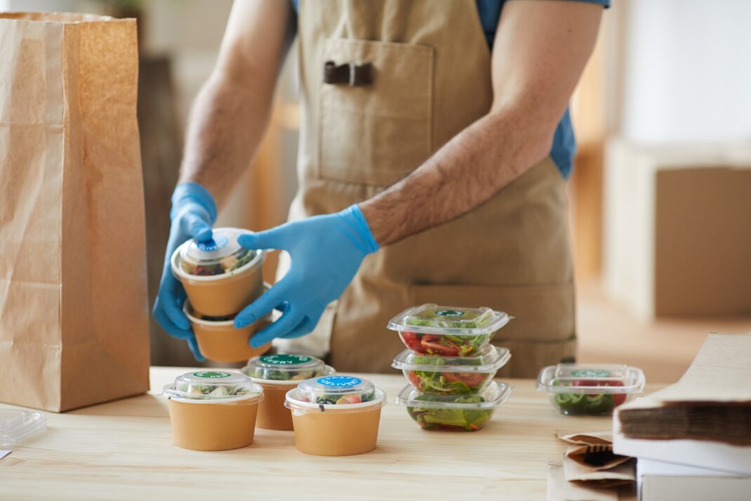 A worker packing food into a bag